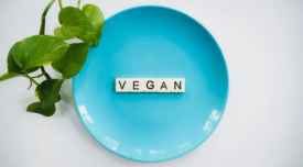 scrabble tiles spelling vegan on a blue plate