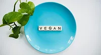 scrabble tiles spelling vegan on a blue plate scrabble tiles spelling vegan on a blue plate