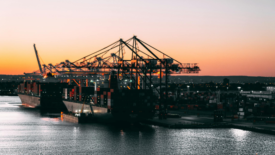 shipping port with cranes at sunset