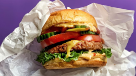 veggie burger white wrapper purple background