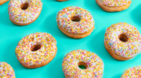 white frosted donuts rainbow sprinkles blue background