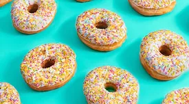 white frosted donuts rainbow sprinkles blue background