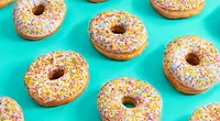 white frosted donuts rainbow sprinkles blue background