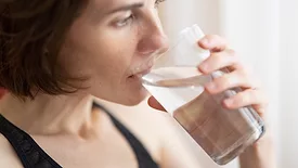 woman drinking glass of water close up from the side