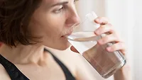 woman drinking glass of water close up from the side woman drinking glass of water close up from the side