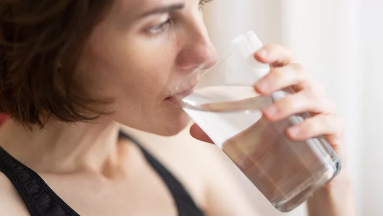 woman drinking glass of water close up from the side