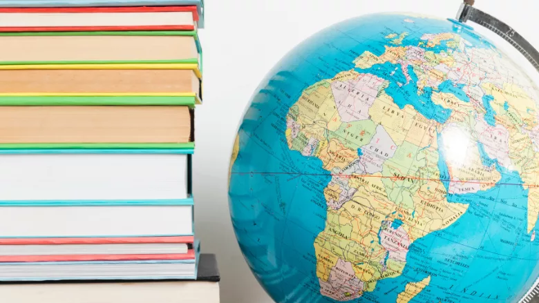 stack of books and globe with africa continent