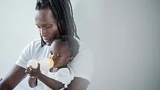 baby drinking bottle with dad