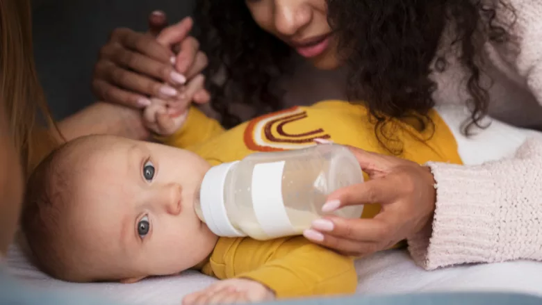 baby drinking bottle with mom