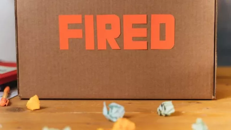 cardboard box on a desk that says FIRED