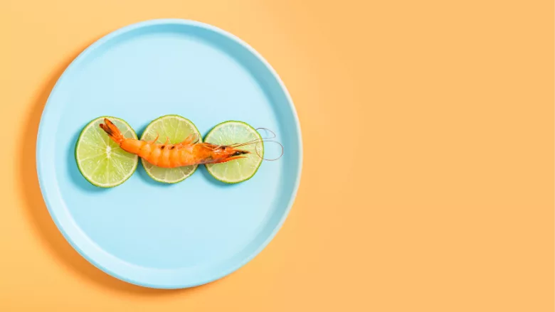 cooked prawn plated with lime slices