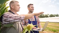 corn farmers laptop.png farmers in corn field with a laptop