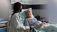 doctor bedside with elderly hospital patient