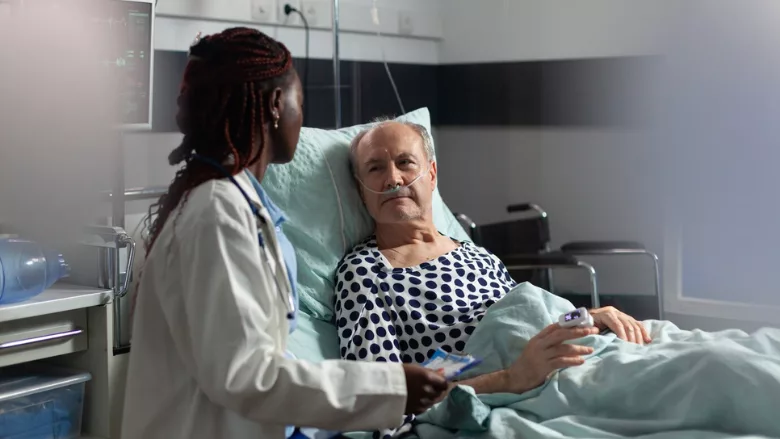 doctor bedside with elderly hospital patient