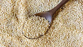 dry quinoa and a wooden spoon