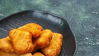 frozen chicken nuggets that have been cooked served on a plate