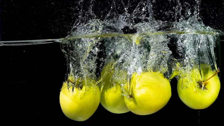 green apples dropped into water