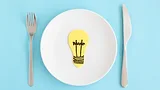 lightbulb on a plate next to fork and knife representing food innovation ideas lightbulb on a plate next to fork and knife representing food innovation ideas