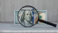 magnifying glass focused on $100 bill
