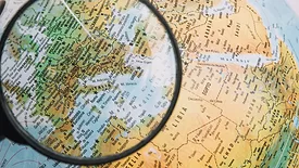 magnifying glass hovering over europe on globe