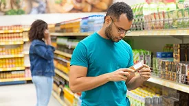male shopper reading food product label