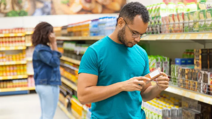 male shopper reading food product label