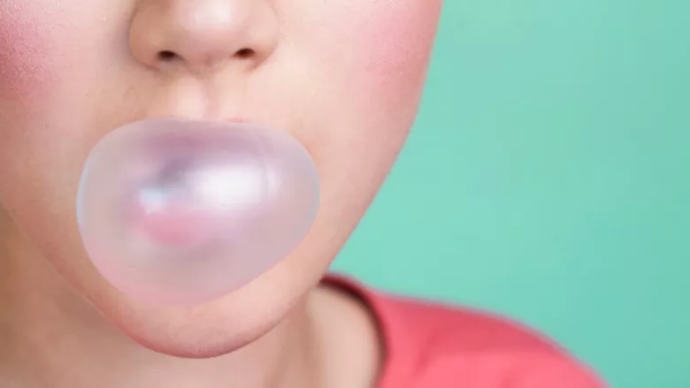 person blowing bubble of gum