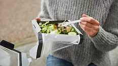 person eating prepacked salad