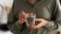 person holding glass of water in both hands person holding glass of water in both hands