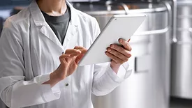person using tablet in beverage production facility