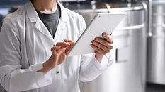 person using tablet in beverage production facility