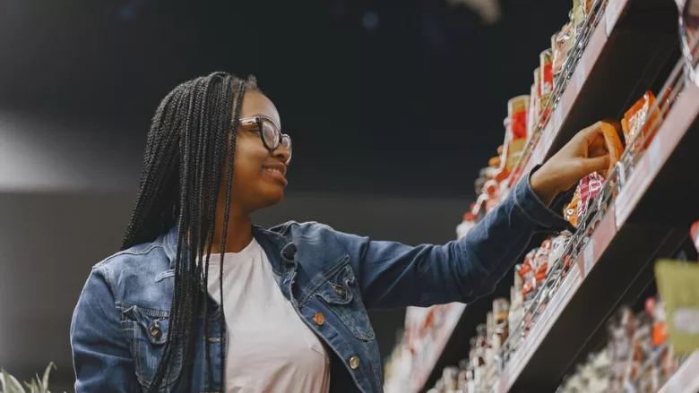 woman shopping looking at packaged food label