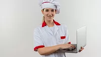 young person in cook's uniform holding laptop smiling at camera young person in cook's uniform holding laptop smiling at camera