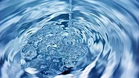 a stream of water falling into a swirling pool_bedneyimages via magnific.png a stream of water falling into a swirling pool of clear blue