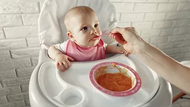 baby being fed puree in high chair