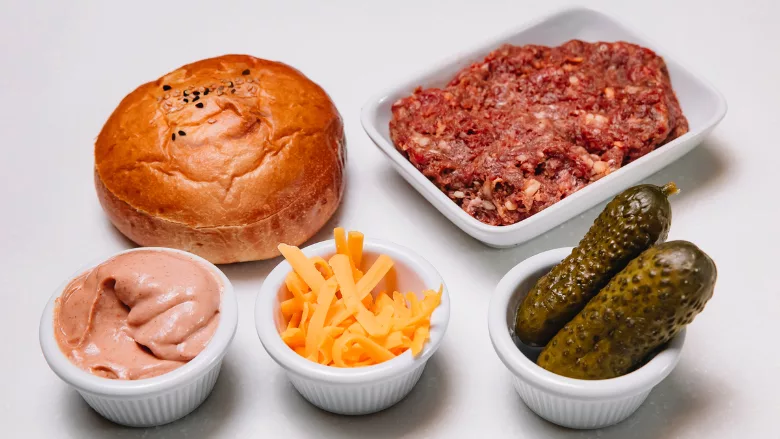 burger ingredients (bun, cheese, pickle, ground beef, sauce) representing foods of different levels of processing
