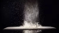 cloud of flour on black background_v.ivash via freepik.png cloud of flour spreading into the air against a black background