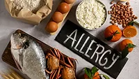 common food allergens with ALLERGY written on table_Freepik via Magnific.png common food allergens and the word ALLERGY