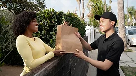smiling man delivering food to smiling woman