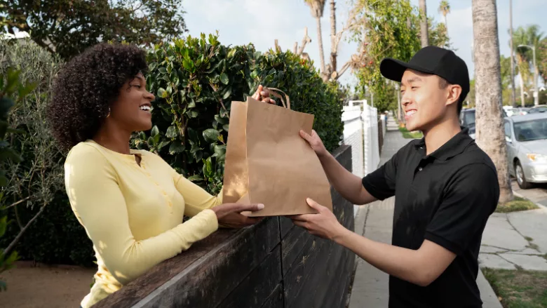 smiling man delivering food to smiling woman