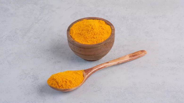 curcumin in wooden spoon and bowl