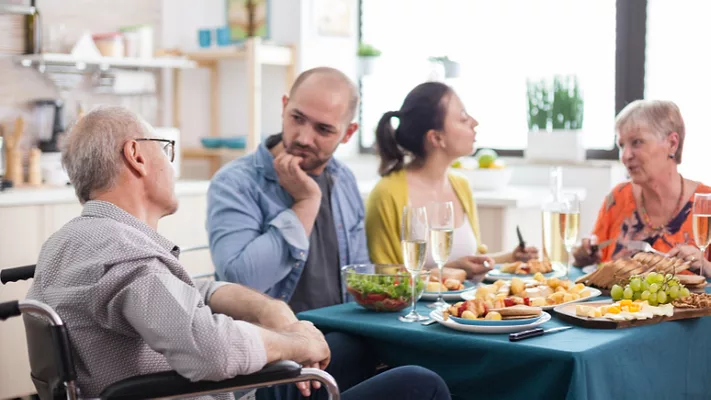 older adult man and woman eating a meal with younger couple