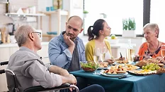 older adult man and woman eating a meal with younger couple