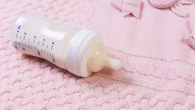 full baby bottle on a pink blanket