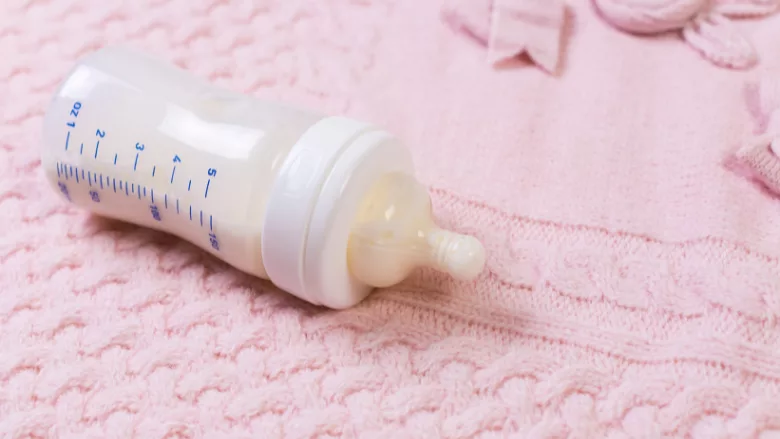 full baby bottle on a pink blanket