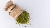 green powder/moringa in wooden mortar