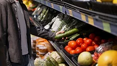 grocery shopper picking up cucumber
