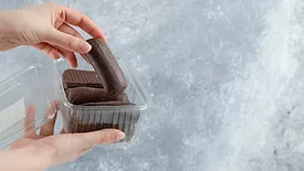 hand pulling chocolate out of plastic package