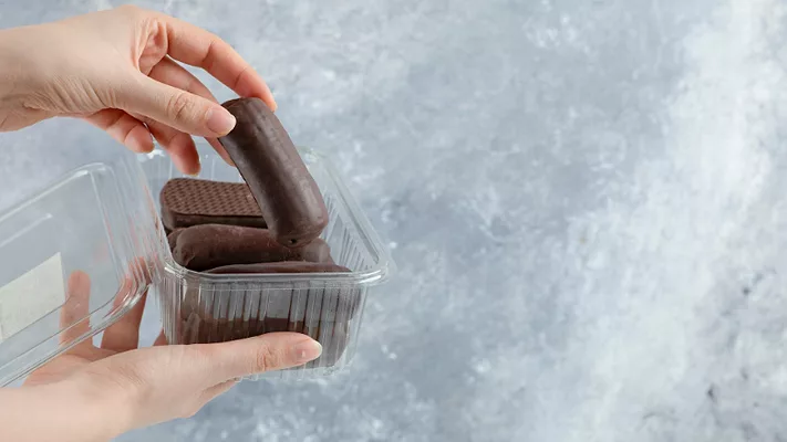 hand pulling chocolate out of plastic package_azerbaijan_stockers via Magnific.png hand pulling chocolate out of plastic package