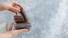 hand pulling chocolate out of plastic package